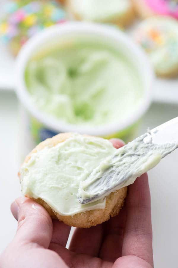 Spreading frosting on a sugar cookie