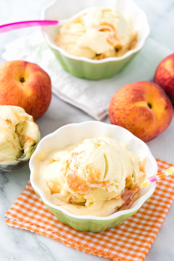 2 bowls of olive oil ice cream surrounded by fresh peaches