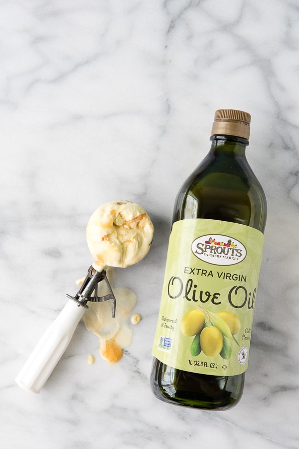 scoop of Olive Oil Ice Cream next to a bottle of Sprouts olive oil