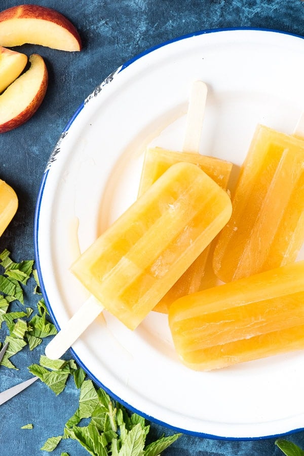 overhead image of Peach Ginger Mint Paletas {popsicles} on a white plate