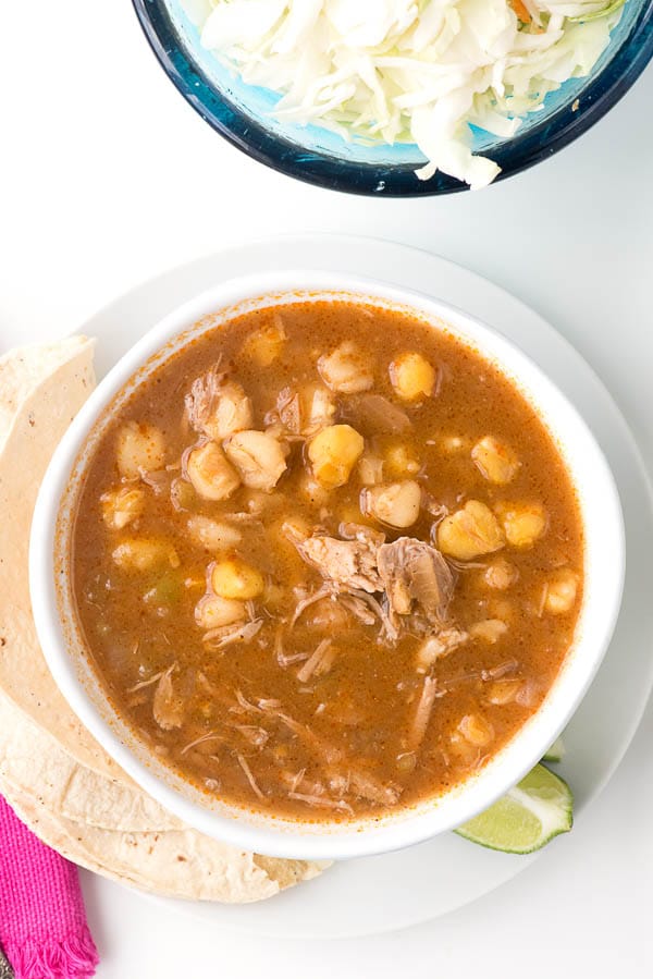 Posole with shredded pork in a white bowl