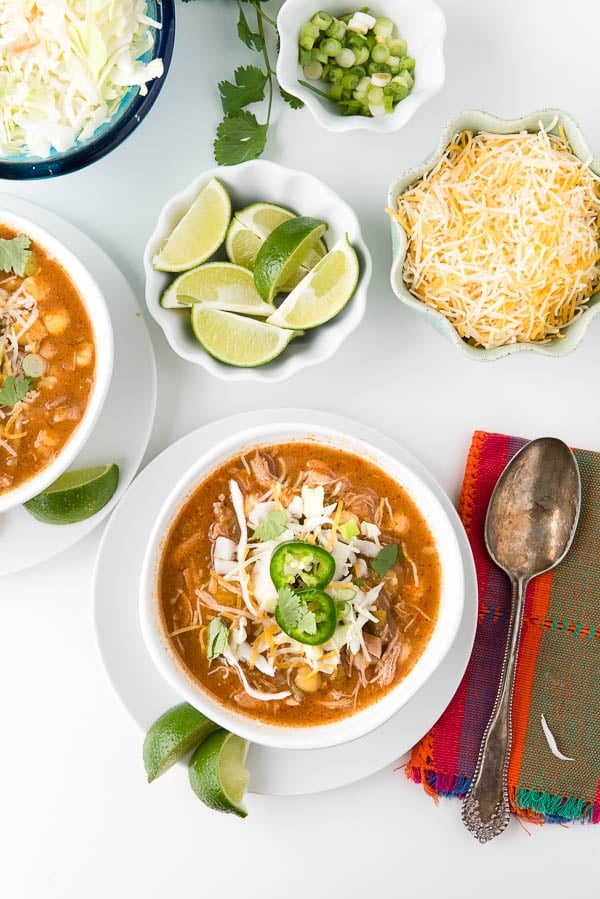 Red Posole in white bowls with garnishes