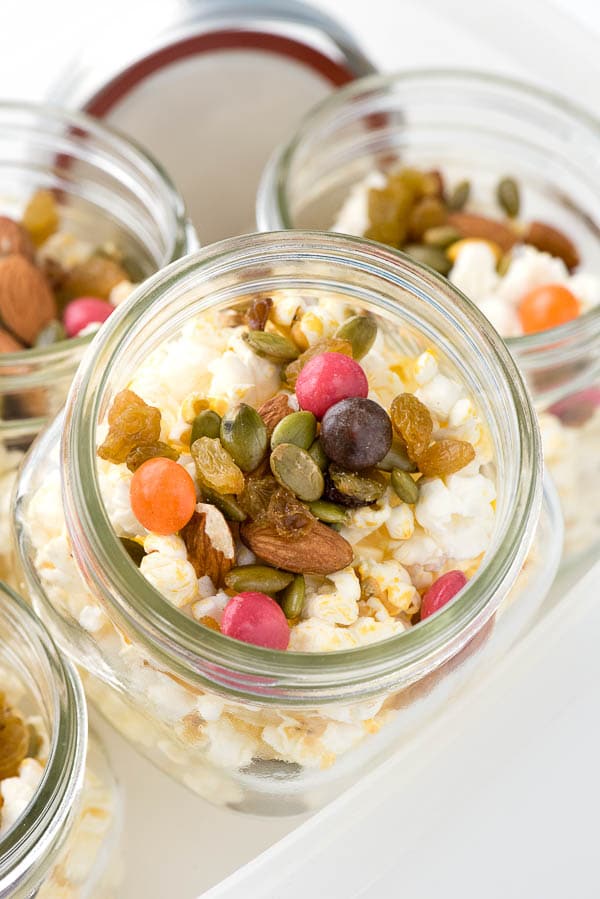 overhead image of a glass mason jar filled with gluten free popcorn snack mix