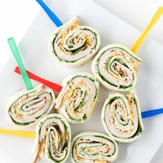 white platter full of Smoked Turkey Spinach Pinwheels with fresh Herb Cream Cheese.