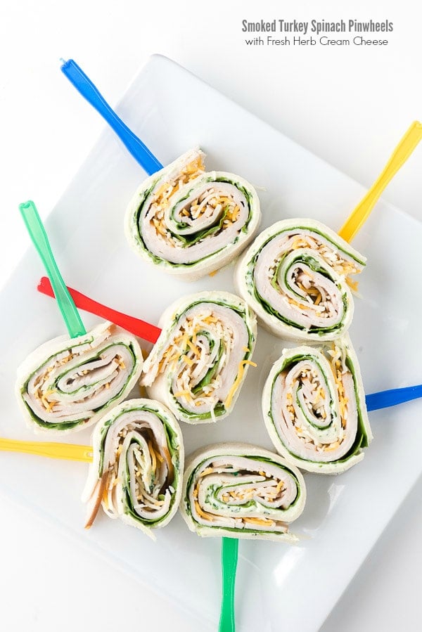 white platter full of Smoked Turkey Spinach Pinwheels with fresh Herb Cream Cheese.