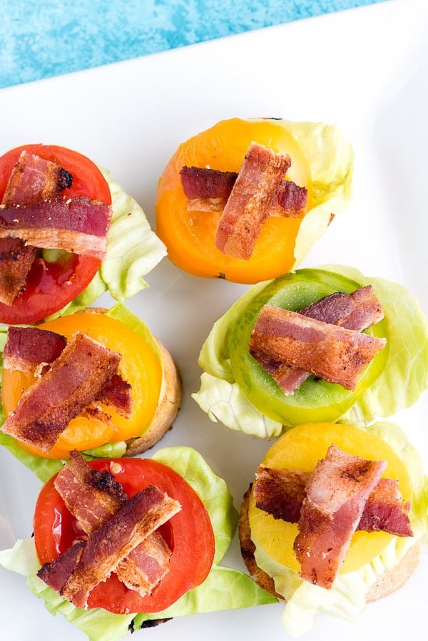 overhead image of bruschetta appetizers, topped with lettuce tomato and bacon