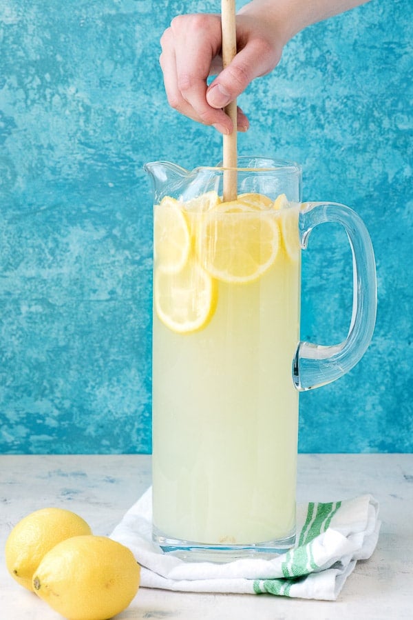 glass pitcher of fresh lemonade with lemon slices