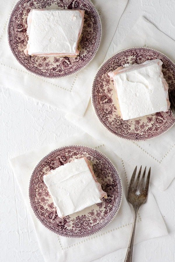 overhead image showing 3 dessert plates with a layered strawberry cheesecake dessert