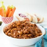 Slow Cooker Barbecue Beans with Bacon with hot dogs in background