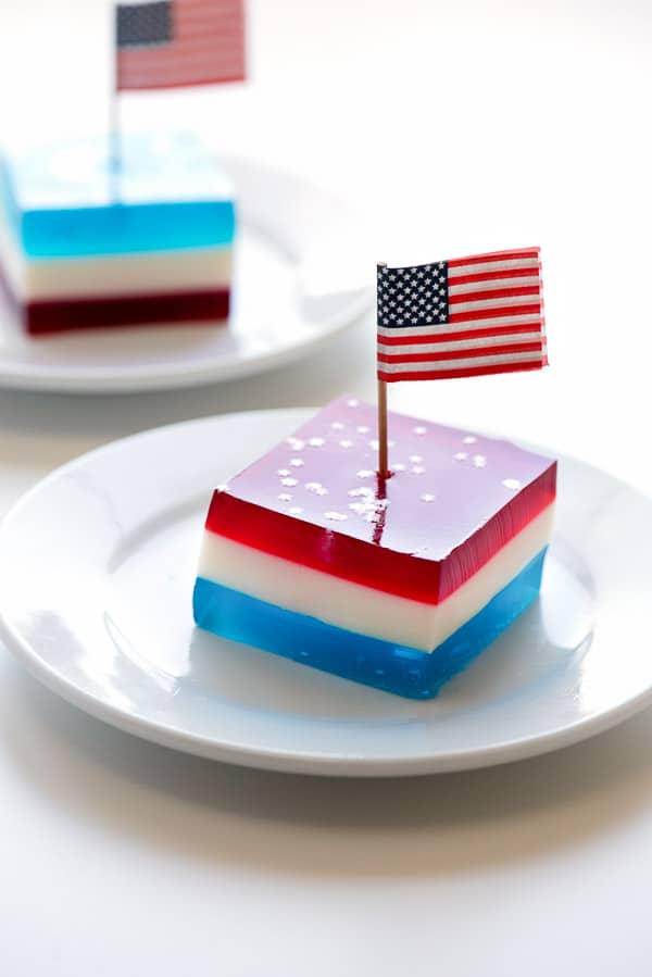 Layered red white and blue finger jello squares on a white plate