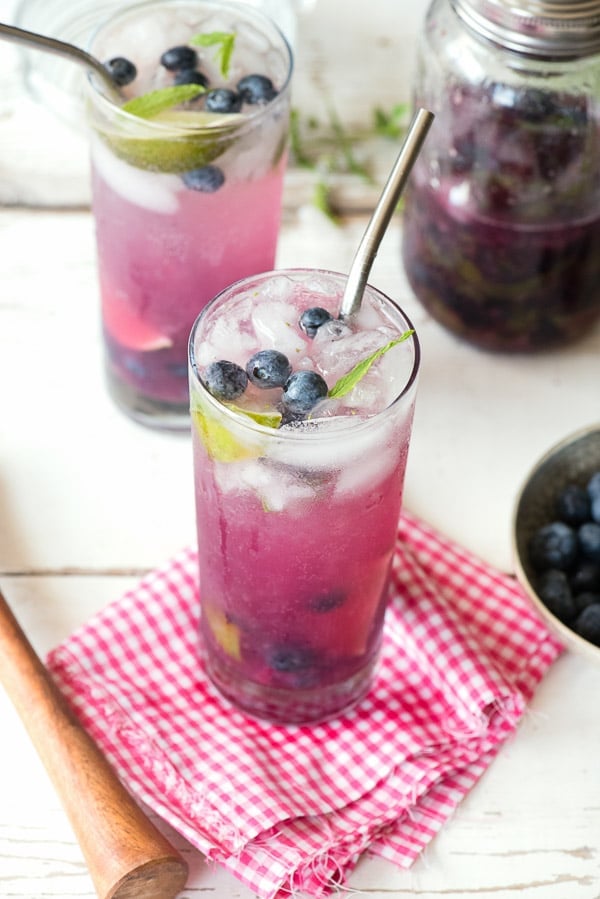 overhead view of blueberry mojitos with bowl of blueberries