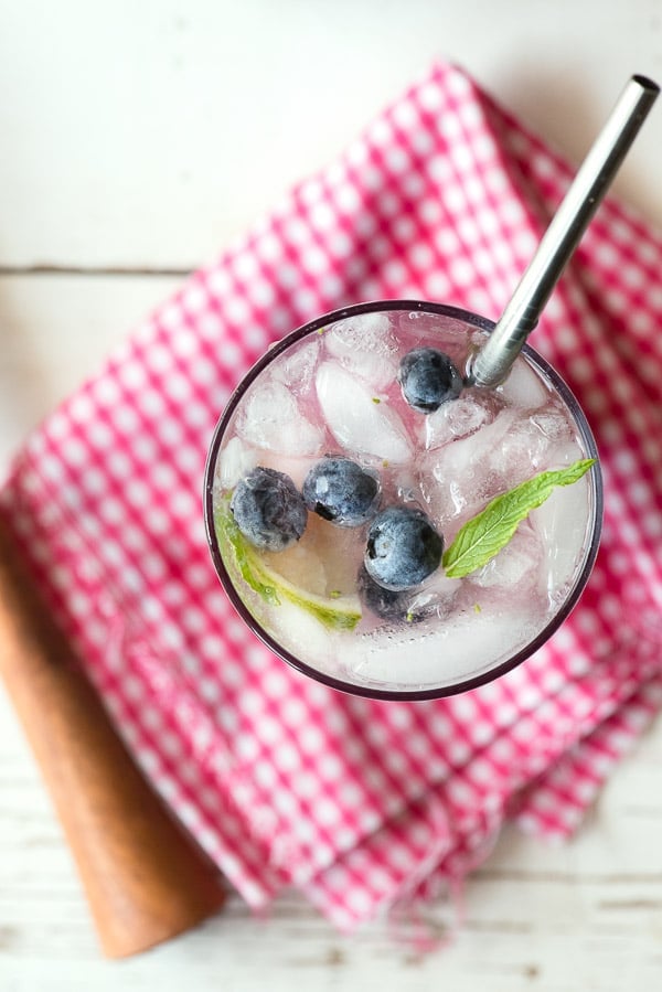 overhead view of blueberry mojito on pink checked cloth