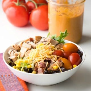 Mexican Cobb Salad with Roasted Tomato Dressing. A hearty, main dish salad bursting with flavor and color. Fresh lettuce, grilled chicken breast, bacon, cherry tomatoes, grated cheese, corn and Roasted Tomato Dressing - BoulderLocavore.com