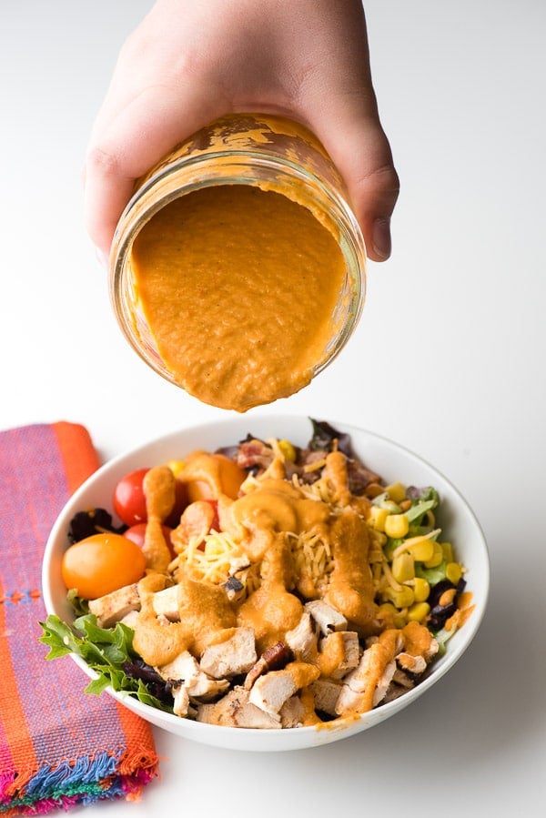 pouring Roasted Tomato Dressing on Mexican Cobb Salad