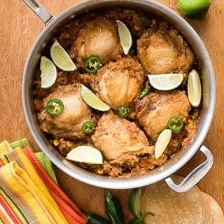 Mexican Chicken and Rice Skillet in a large skillet on wooden cutting board