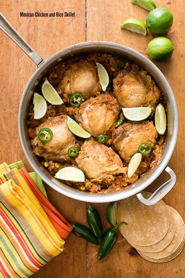 Mexican Chicken and Rice Skillet in a large skillet on wooden cutting board