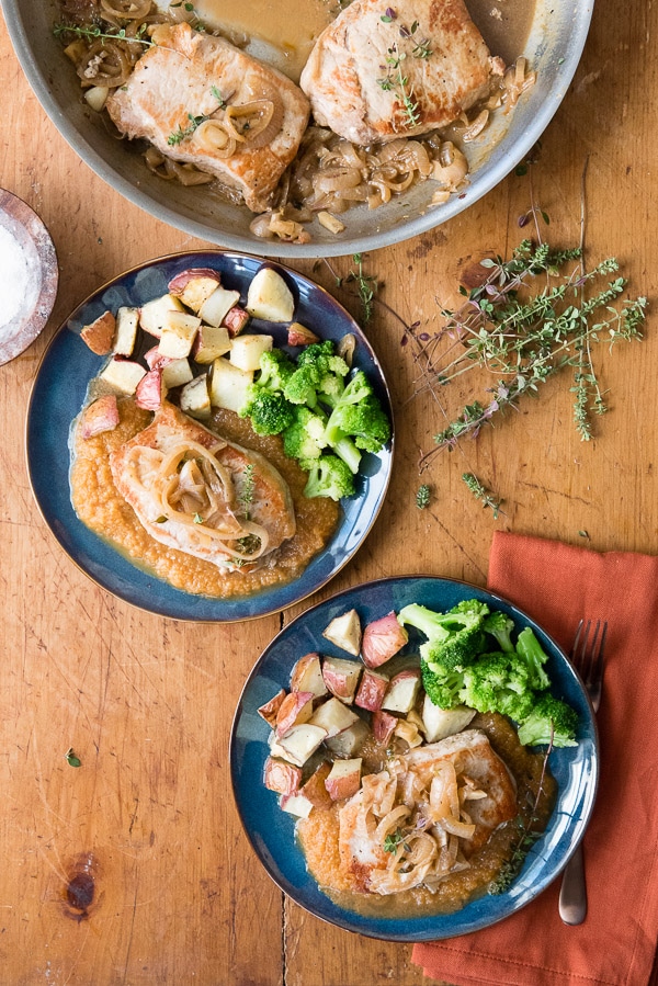 Overhead of plates of Pumpkin Spice Apple Sauce with Pumpkin-Cider Braised Pork Chops