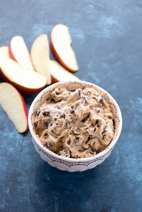 Pumpkin Spice Cookie Dough Dip in a bowl with apple slices behind