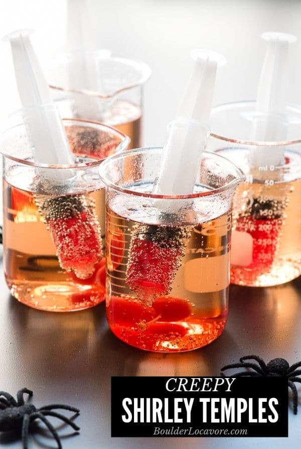 creepy Shirley Temple drinks for Halloween in beakers with syringes