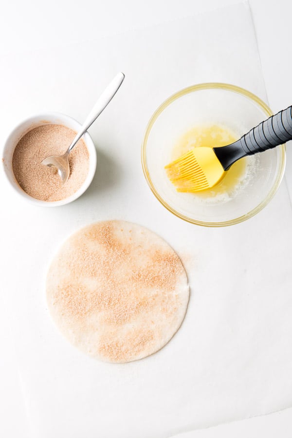 adding cinnamon sugar to tortillas