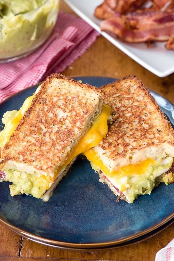 Grilled Triple Cheese Bacon Guacamole Sandwich on a blue plate