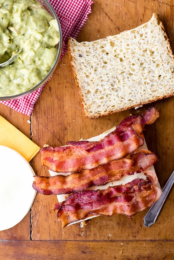 bacon on cheese sandwich with guacamole in bowl