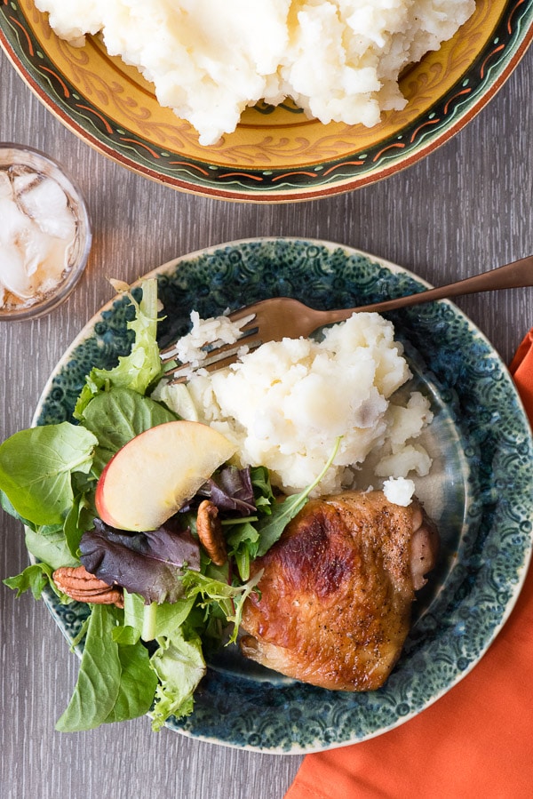 dinner plate with roasted chicken thighs and side dishes