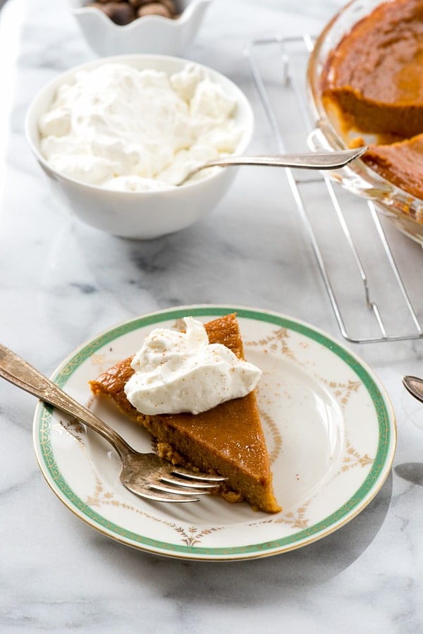 Fetta di torta di zucca senza crosta su un piatto con panna montata sopra