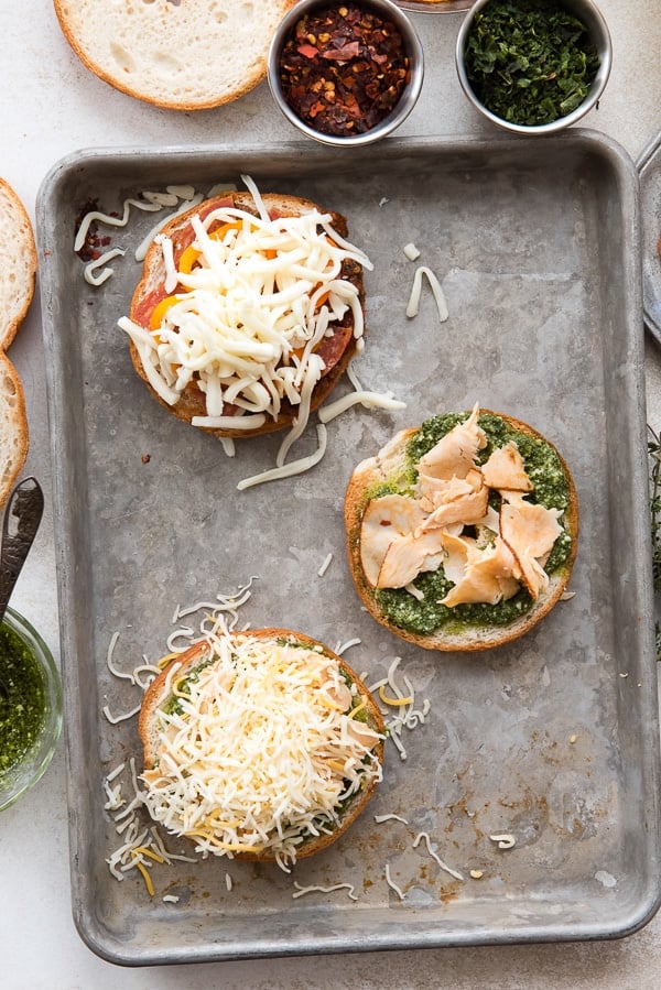 variety of bagel pizzas on baked ng sheet