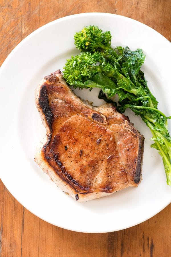 pan fried pork chop with rapini on a plate