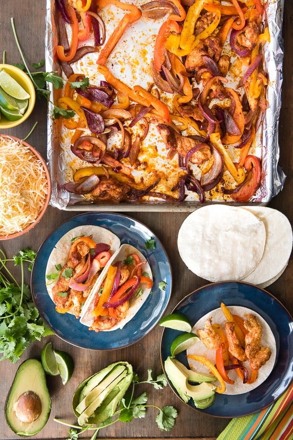 Sheet Pan chicken fajitas with plates of prepared fajitas