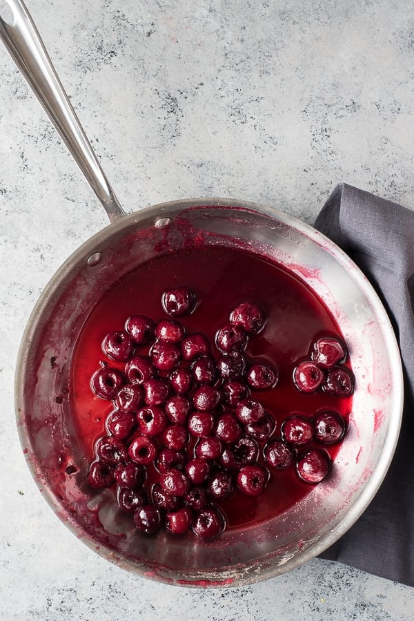 Flambeed cherries in skillet for Cherries Jubilee