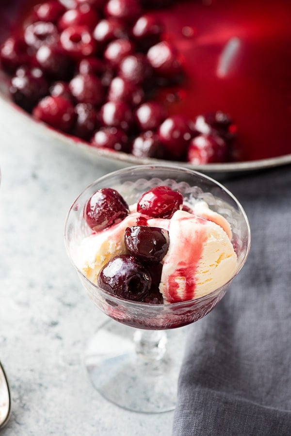 Cherries Jubilee with Vanilla Ice Cream. Liqueur-soaked cherries flambéed with rum and served over ice cream