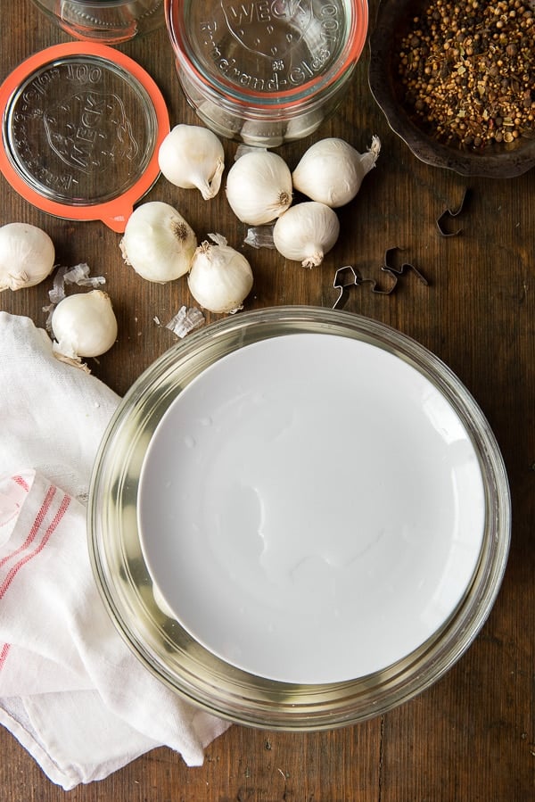 onions in bring in a bowl with plate on top to hold onions down