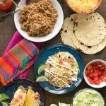 shredded taco chicken, tortillas and toppings for soft tacos