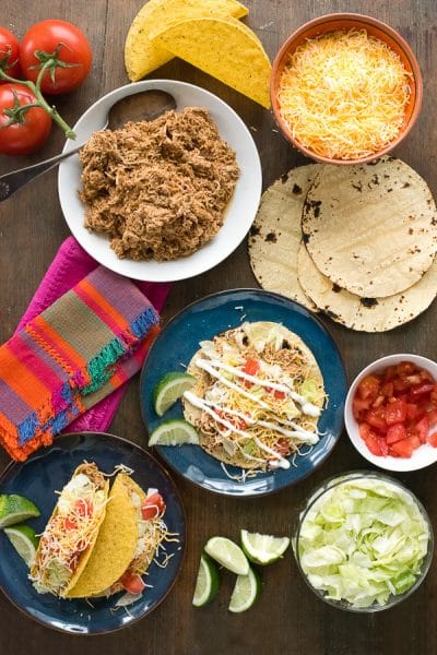 shredded taco chicken, tortillas and toppings for soft tacos