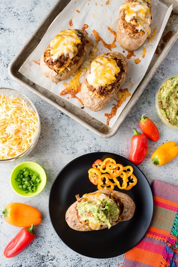 Taco-Stuffed Baked Potatoes on baking sheet and plate