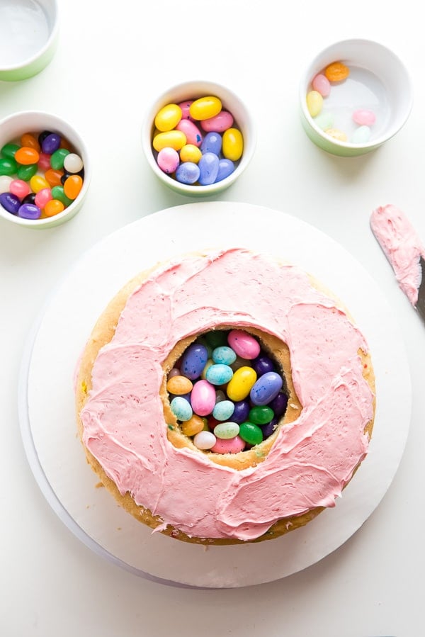 making a pinata cake with hole in top layer with candy in middle