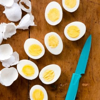 Halved Instant Pot hard boiled egg recipe with blue knife