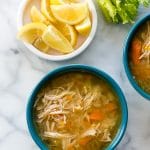 Instant Pot Hearty Chicken Soup in a blue bowl with lemon wedges from above