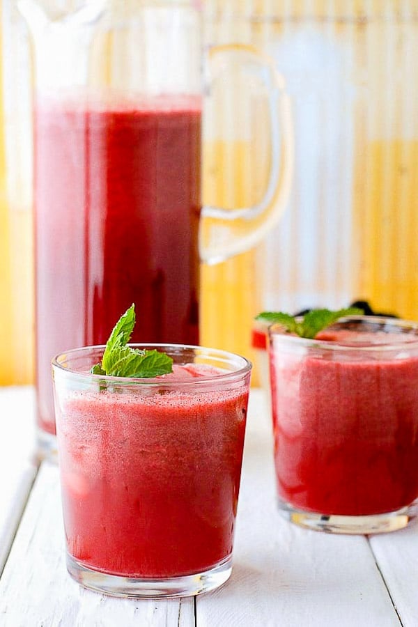 Blackberry Mint Agua Fresca in a glass pitcher with fresh mint