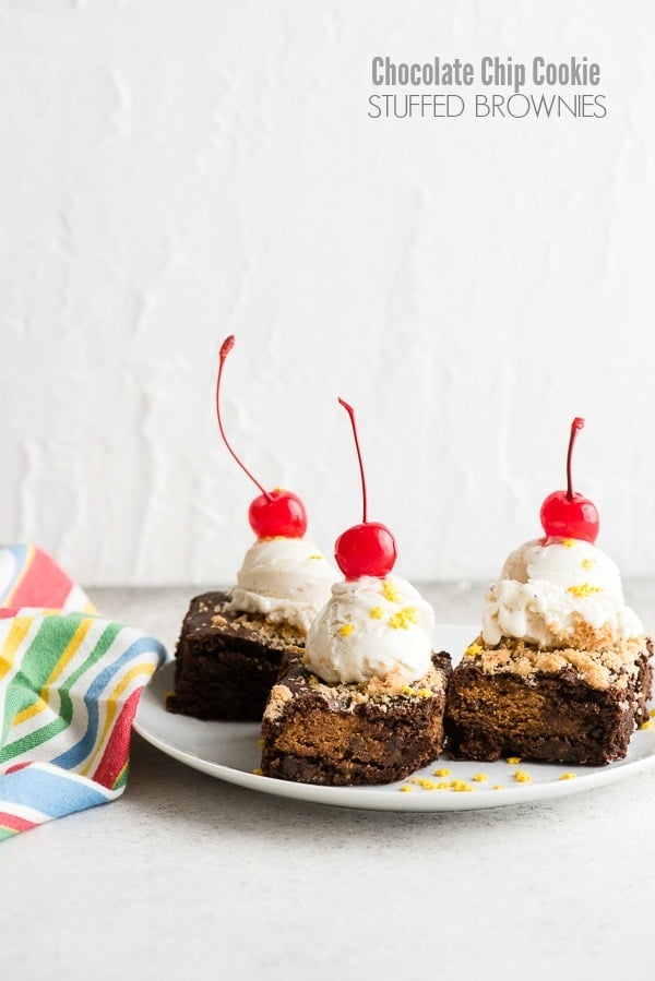 Freshly baked Chocolate Chip Cookie Stuffed Brownies with a scoop of vanilla ice cream and cherries 