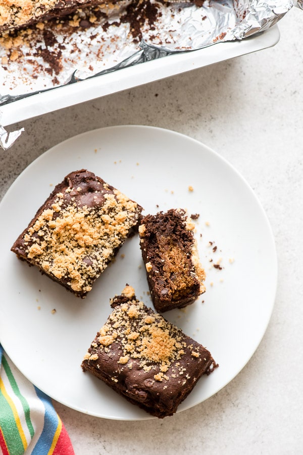 Three fudgy chocolate gluten-free Chocolate Chip Cookie Stuffed Brownies on a white plate 