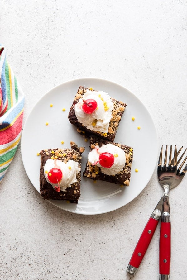 Warm, chewy chocolate chip cookie stuffed brownies with a scoop of vanilla ice cream, sprinkles and maraschino cherries 
