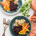 Juicy, fast-to-cook Chili Lime Chicken with sides dishes on green plates with copper silverware