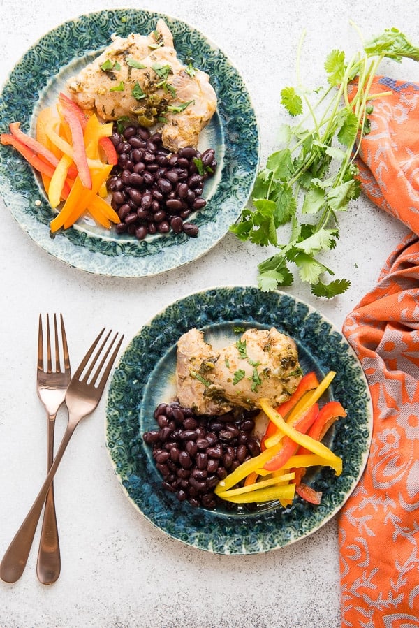 Juicy, fast-to-cook Chili Lime Chicken with sides dishes on green plates with copper silverware