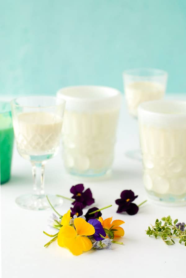 Purple and yellow pansies, fresh thyme sprigs, glasses of rose-flavored panna cotta 