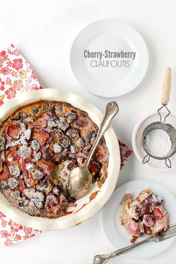 cherry strawberry claufoutis in a pie pan with spoon