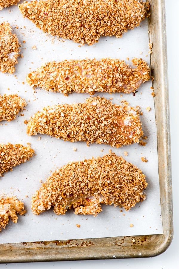 Crispy, breaded gluten-free Taco chicken tenders baked on white parchment paper 