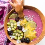 Thick, healthy Tropical Bliss Smoothie Bowl with fresh blackberries, star fruit, kiwi, lime slices, shredded coconut